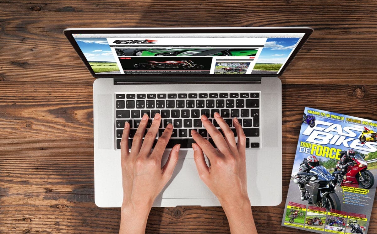 Aerial view of woman typing on laptop. Placed on wooden desk