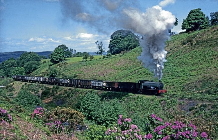 It is 7.40am on May 26, 1978 as Hunslet Austerity 0-6-0ST No. 3770 of 1951 Norma digs in up-grade with the first train of the day beside the native rhododendrons, just four weeks before the official closure of the line up the Dulais Valley to the Graig MERTHYR DRIFT MINE FROM PONTARDULAIS. 