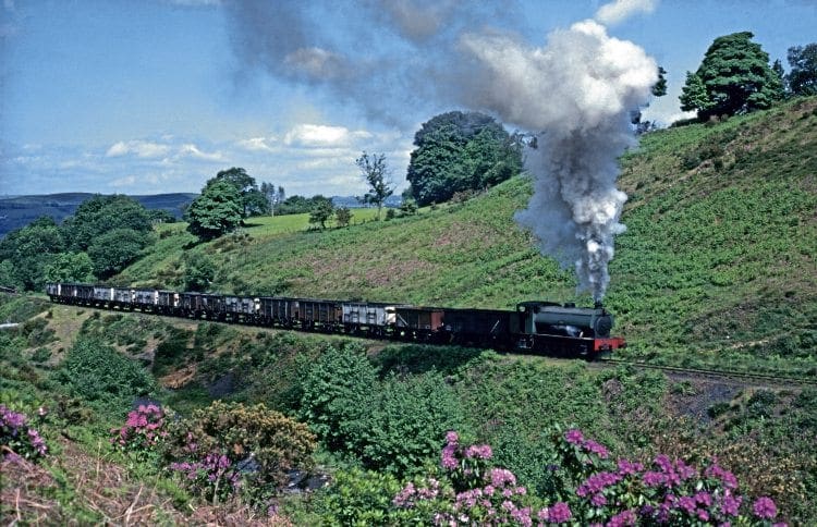 It is 7.40am on May 26, 1978 as Hunslet Austerity 0-6-0ST No. 3770 of 1951 Norma digs in up-grade with the first train of the day beside the native rhododendrons, just four weeks before the official closure of the line up the Dulais Valley to the Graig MERTHYR DRIFT MINE FROM PONTARDULAIS.