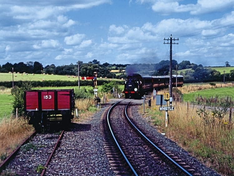 Stroudley A1X ‘Terrier’ 0-6-0T No. 32678 heads the 12.45am departure from Bodiam up the 1-in-50 Tenterden bank and Stroudley A1X ‘Terrier’ 0-6-0T No. 32678 heads the 12.45am departure from Bodiam up the 1-in-50 Tenterden bank and approaches Cranbrook Road crossing on July 31.