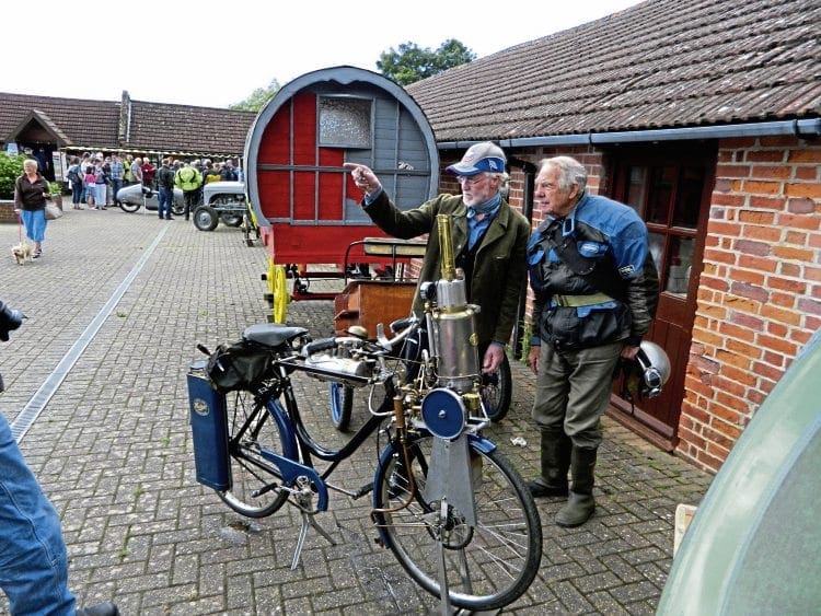 An interesting conversation takes place beside the Hudspith steam bicycle. 