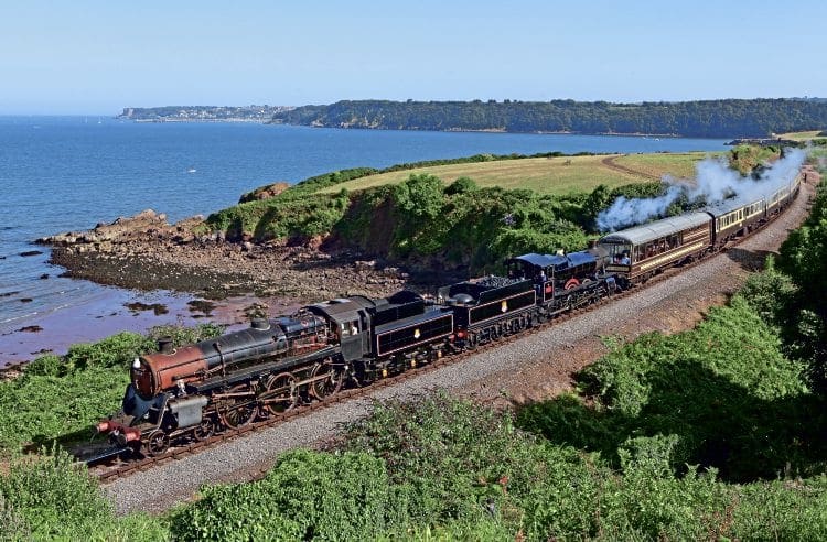 BR comeback 3: Patch-painted ‘4MT’ 4-6-0 No. 75014 pilots No. 7827 Lydham Manor past Waterside, with the 15.40 Kingswear-Paignton service on August 23. ROBERT SHERWOOD 