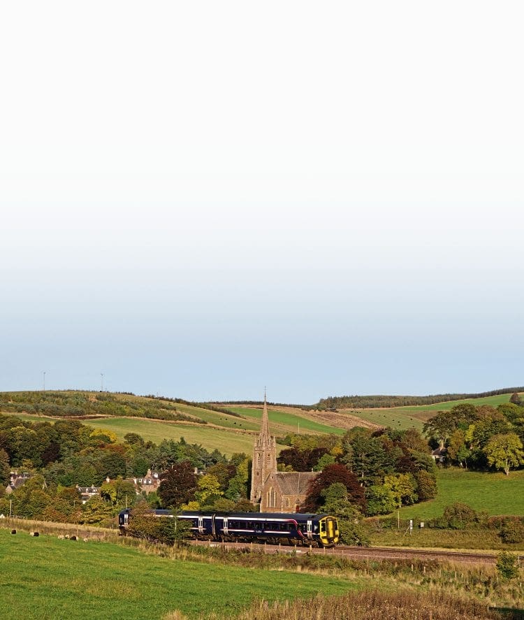 Packed Class 158 No. 158704 restarts an Edinburgh to Tweedbank train from Stow on October 14, 2015, autumn shades evident in the rolling countryside. CHRIS MILNER 